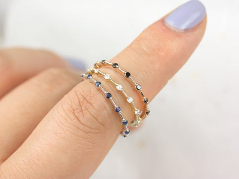 14kt gold blue sapphire halfway eternity ring worn on a finger