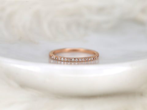 Rose gold ring with small diamonds on a soft white background