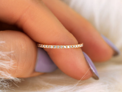 Close-up of a hand wearing a thin diamond ring on a soft background