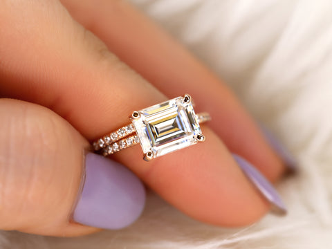 east west set emerald cut solitaire with diamonds on shank and matching diamond band on finger