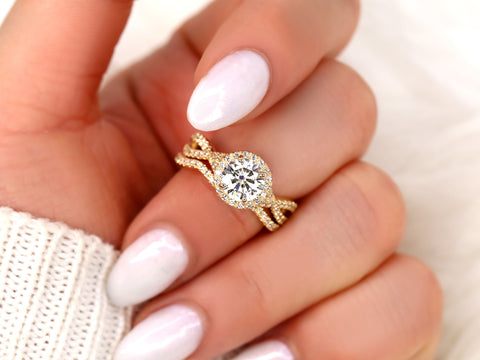 14kt gold bridal ring set with round moissanite center and delicate crossover halo details held between fingers