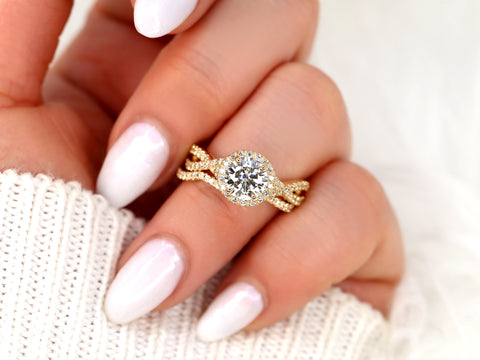 14kt gold moissanite bridal ring with round halo and unique crossover band worn on hand with white nails