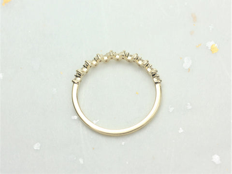 Minimalist 14kt gold ring featuring a row of small diamonds in a halfway eternity design on light stone surface