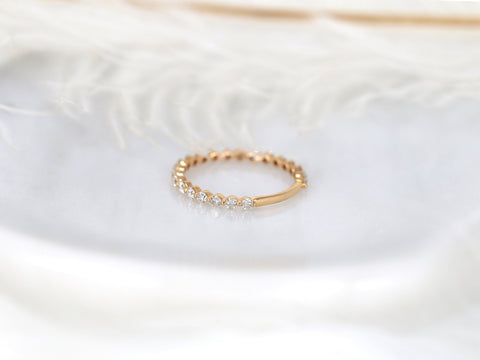 Delicate 14kt rose gold ring with a partial row of small sparkling diamonds on a soft neutral background