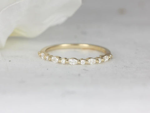 Delicate yellow gold eternity ring with small lab grown diamonds arranged in an alternating marquise and round pattern on soft background