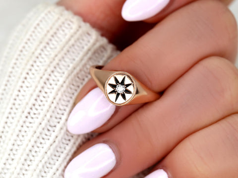 14kt gold star signet ring featuring a central sparkling diamond worn on a finger with pale pink polish