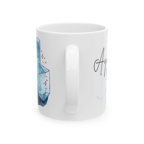 White ceramic mug with blue crystal illustration and partial elegant script viewed from the side with handle centered