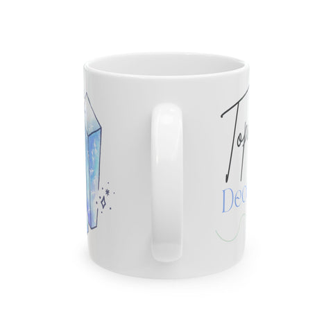 White ceramic mug with blue crystal illustration and partial handwritten text on side view