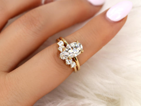 Elegant 14kt gold bridal set featuring a 2.50ct oval moissanite solitaire with accent stones on a hand