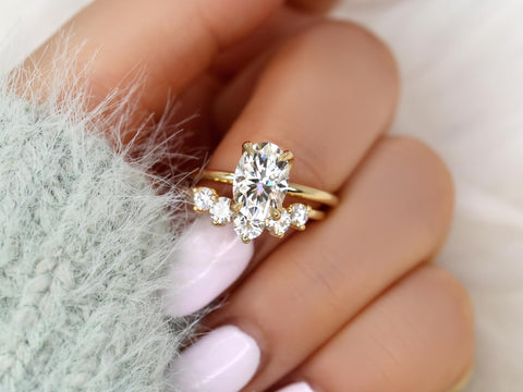 14kt gold bridal set with oval moissanite solitaire and curved accent band on a manicured hand
