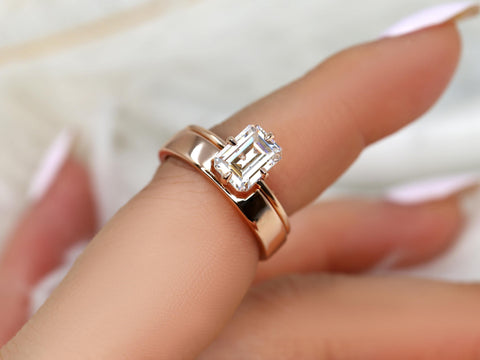 14kt gold bridal set featuring an emerald cut moissanite solitaire on a polished band worn on finger