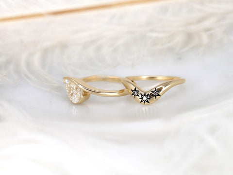 14kt gold bridal set with tilted pear-shaped moissanite and constellation-inspired star accents on wedding bands