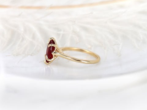 Slim 14kt gold solitaire ring with marquise-shaped deep red ruby on delicate band on soft white background