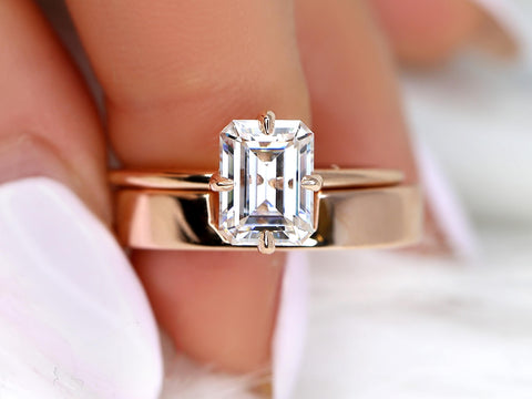 14kt gold bridal set featuring an emerald cut moissanite solitaire on a polished band against a soft background