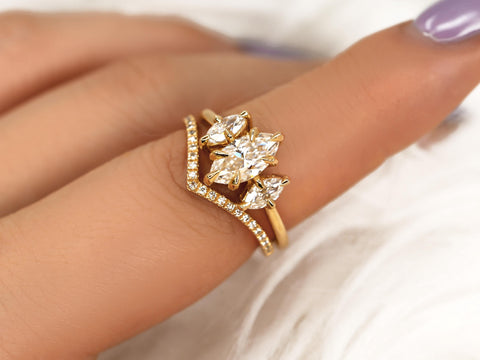 Gold three-stone marquise moissanite bridal set with diamond-accented chevron wedding band on finger