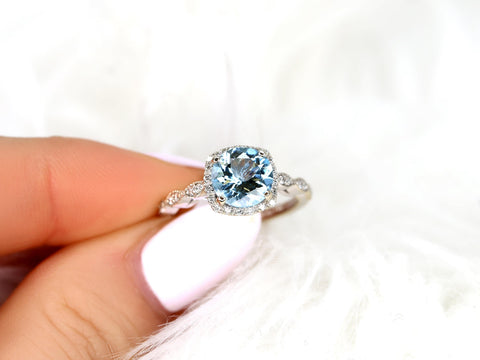 Delicate aquamarine center stone with diamond halo and milgrain detailing on an elegant white gold band fine jewelry ring