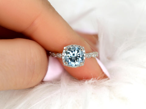 Close-up of an 8mm aquamarine center stone surrounded by a diamond halo on a delicate 14kt gold ring band.