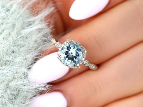 Close-up of a hand wearing an 8mm aquamarine ring with milgrain diamond halo on a delicate 14kt gold band.