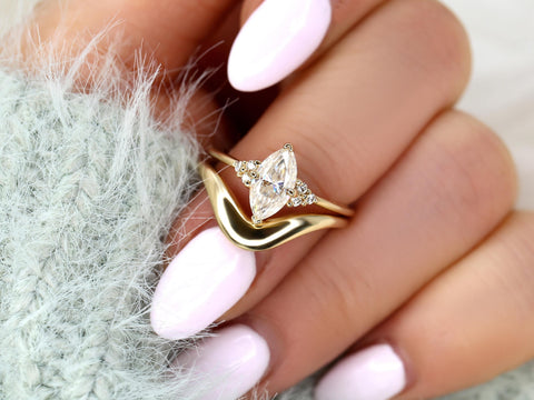 Hand holding a 14kt gold moissanite marquise engagement ring paired with a curved wedding band, fine bridal jewelry.