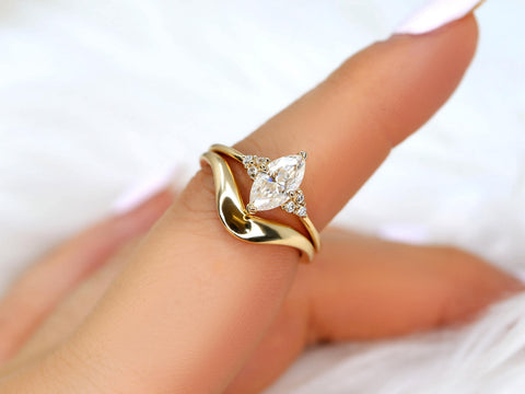 Elegant bridal set featuring a marquise moissanite engagement ring with a curved 14kt gold wedding band on a hand
