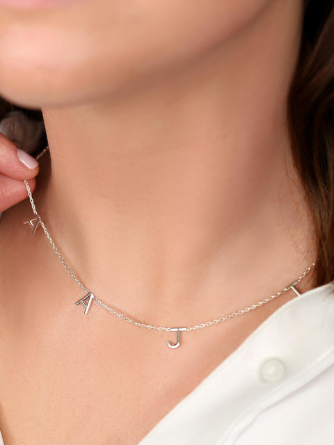 Necklace with letter 'J' pendant worn by a person