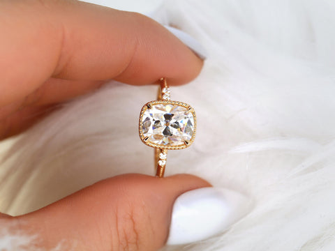 antique cut cushion button back solitaire with diamond accents held between thumb and pointer finger