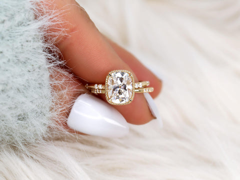 antique cushion button back ring with milgrain edge paired with a open diamond band with pointed opening shown between pointer and thumb finger over white background