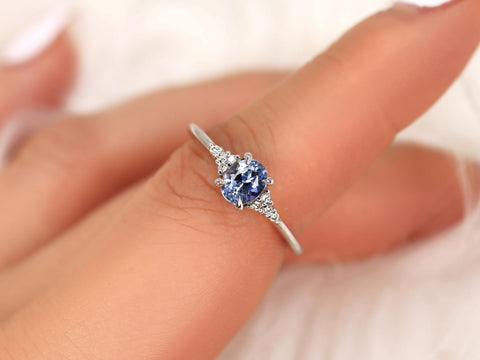 oval cluster ring with cornflower sapphire center stone over pointer finger