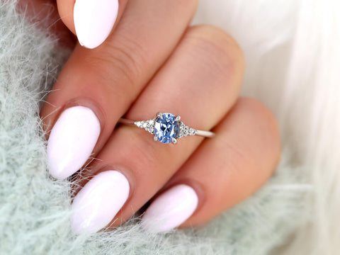 oval cluster ring with cornflower sapphire center stone on ring finger over sleeve