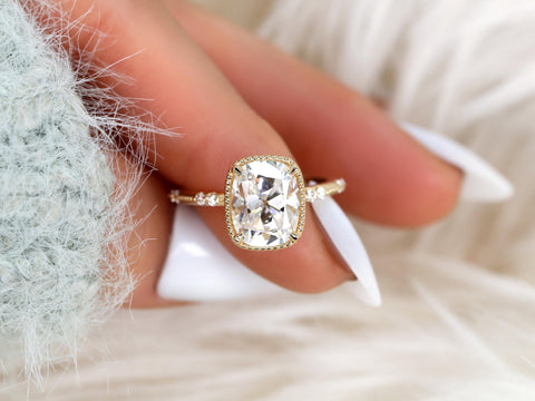 antique cut cushion button back solitaire with diamond accents on a finger with white nail polish and white background
