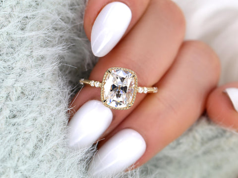 antique cut cushion button back solitaire with diamond accents on middle finger with white nail polish and white background
