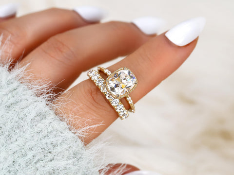 antique cushion cut button back ring with accent diamonds paired with a thick diamond band on a finger