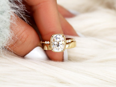 antique cushion solitaire with button back, claw prongs, and diamond accents on band. the ring is paired with a chevron solid gold band pinched over white background