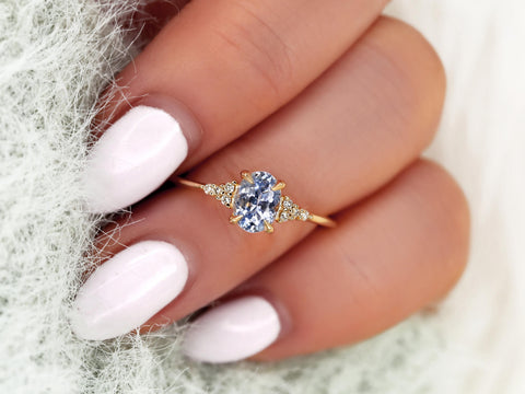 oval cornflower lilac sapphire cluster ring with dainty diamonds on ring finger
