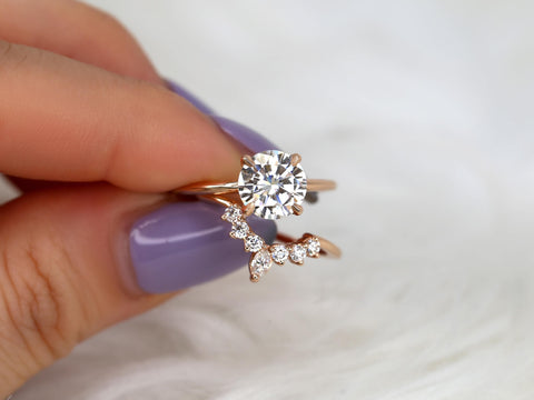 round solitaire moissanite paired with a unique diamond nesting band in 14kt rose gold pinching between finger