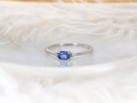 oval cornflower blue sapphire ring in trilogy style with two diamonds on white gold on white background