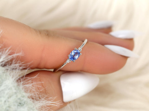 oval cornflower blue sapphire ring three stone style with two diamonds on white gold on pointed finger