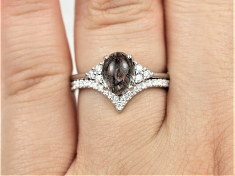 Oval tourmalinated quartz center with diamond cluster and diamond wedding band in 14kt gold bridal set on finger