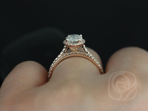 14kt gold bridal set with sparkling oval moissanite center and diamond-accented band on finger against dark background