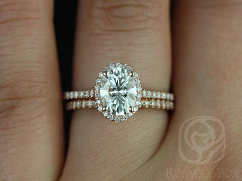 Oval moissanite bridal set in 14kt gold with diamond halo and pavé diamond wedding band on finger