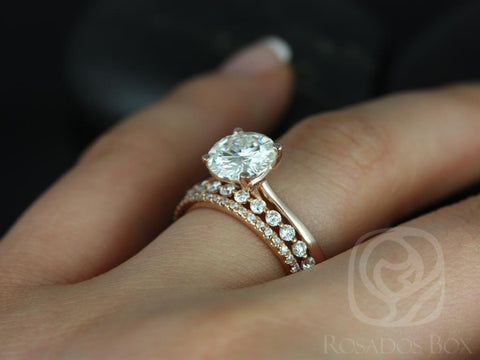 14kt gold bridal set with round moissanite solitaire and a delicate diamond-accented wedding band on finger