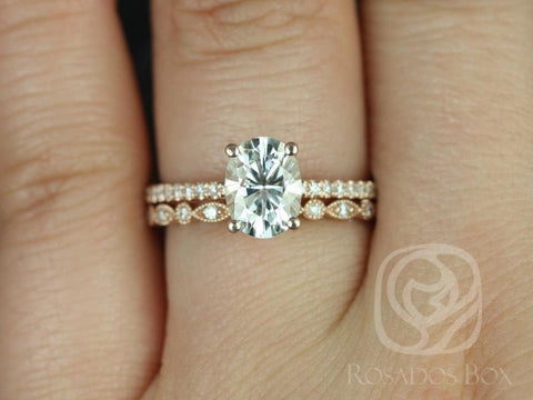 Oval moissanite solitaire engagement ring paired with a detailed diamond-accented wedding band in 14kt gold