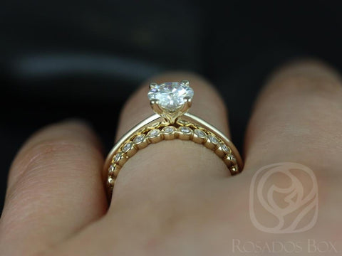 14kt gold solitaire engagement ring with petite diamond-accented wedding band on finger against dark background