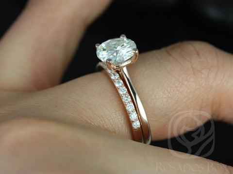 14kt gold bridal set with round moissanite solitaire and slim diamond-accented wedding band on finger