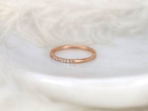 Rose gold ring with small diamonds on a soft white background