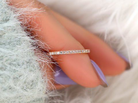 Close-up of a hand wearing a diamond ring on a soft, white background