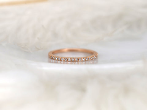 Rose gold ring with small diamonds on a soft white background