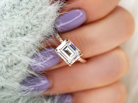 east west set emerald cut solitaire with diamonds on band on middle finger