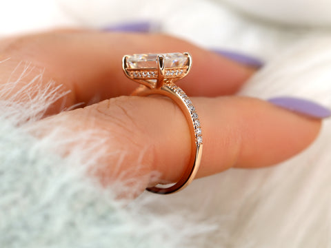 Rose gold ring with diamonds on a finger against a blurred background