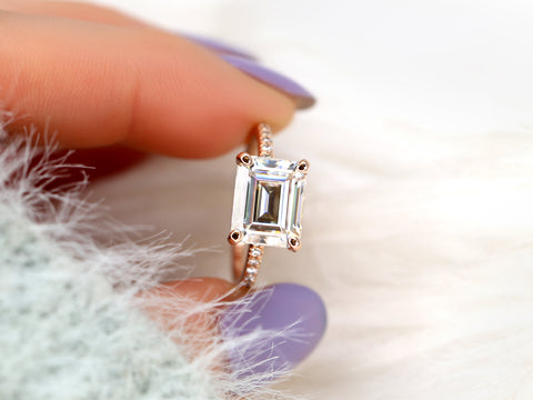 east west set emerald cut solitaire with diamonds on band between fingers